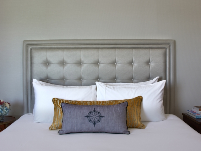 Pillows neatly stacked on a large king sized bed.