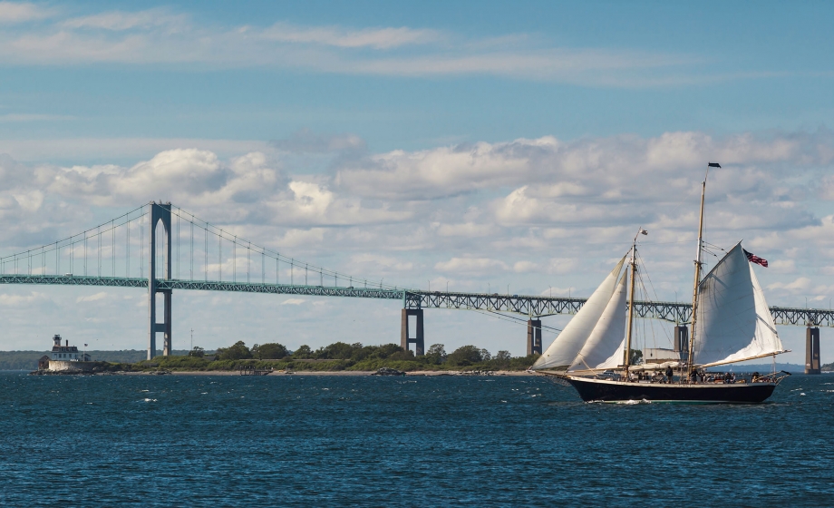 School ship sailing with a bridge in the background