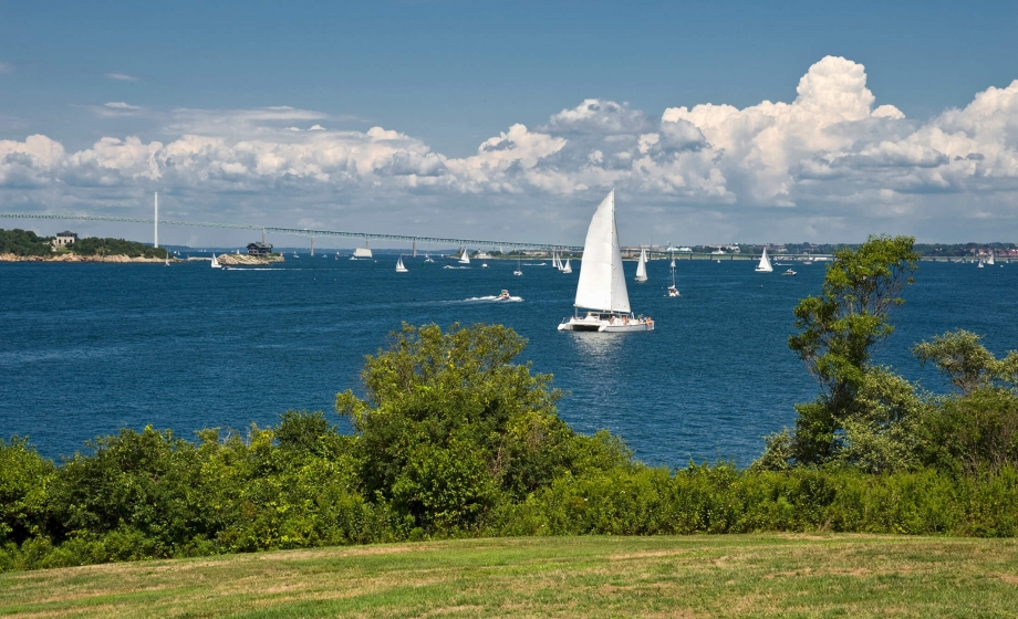 A sailing ship out in the water with a blue sky in the background