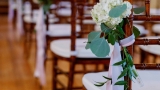 Image of wedding guest seating with a bouquet of flowers.