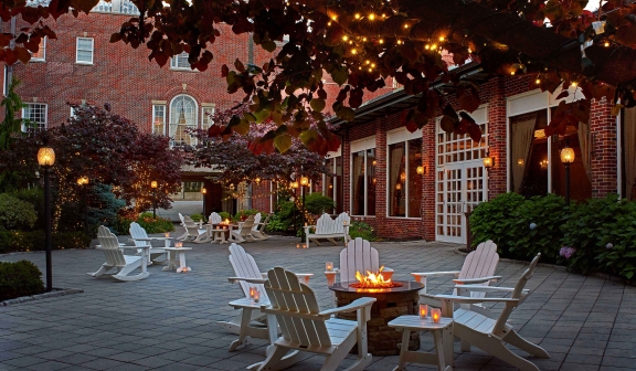 Courtyard with outdoor fireplaces and desk chairs at dusk