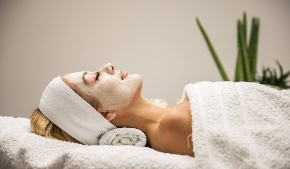 A woman relaxing at the spa with a mud mask on