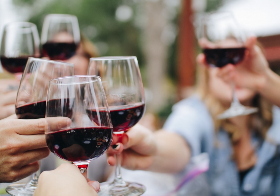 Individuals cheersing wine glasses