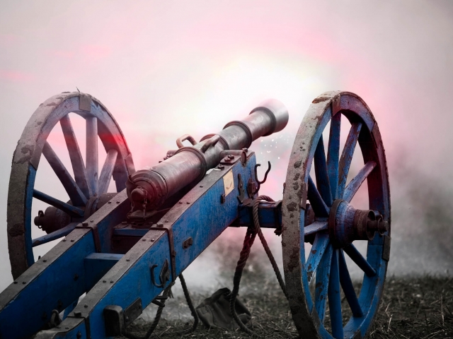 An old military cannon firing with smoke